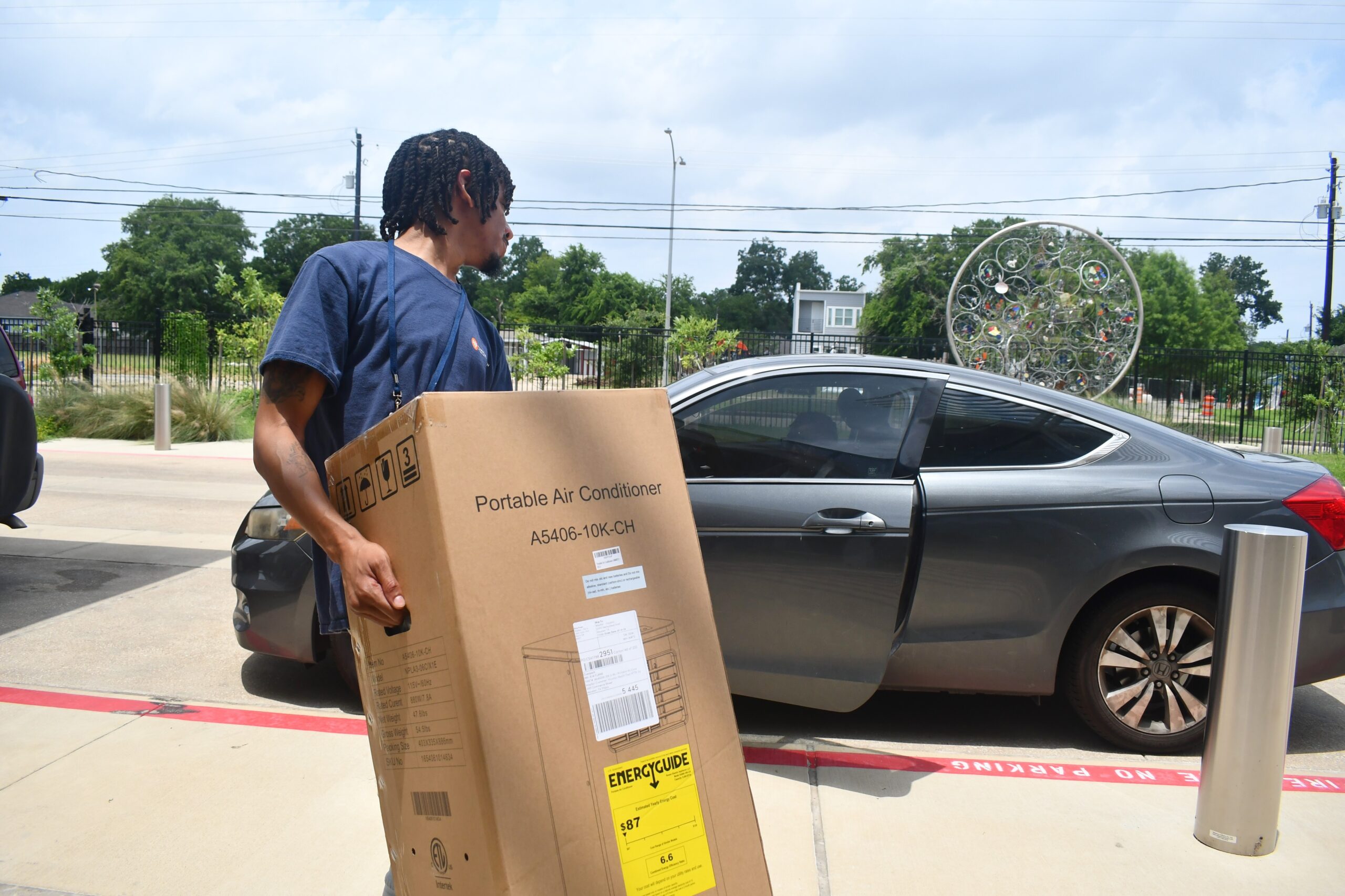 Houston Health Department worker loads a free AC unit into a car