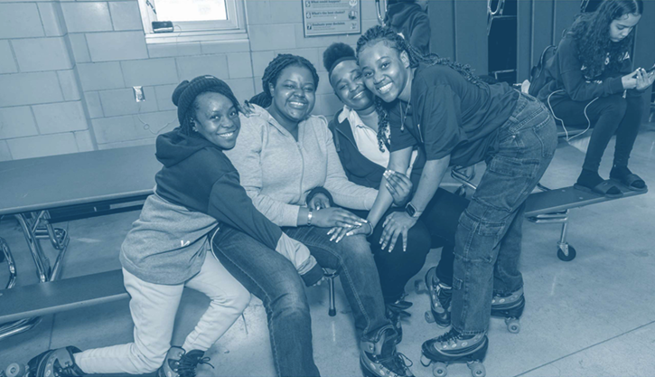 Group of teens sitting closely together on a bench