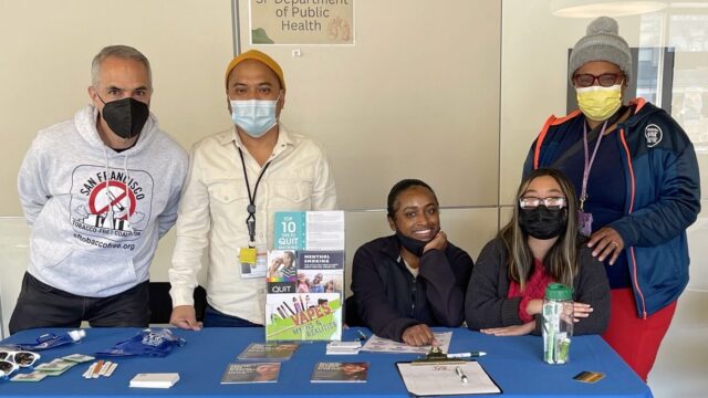 San Francisco Department of Public Health workers standing at a table for the city's tobacco-free coalition