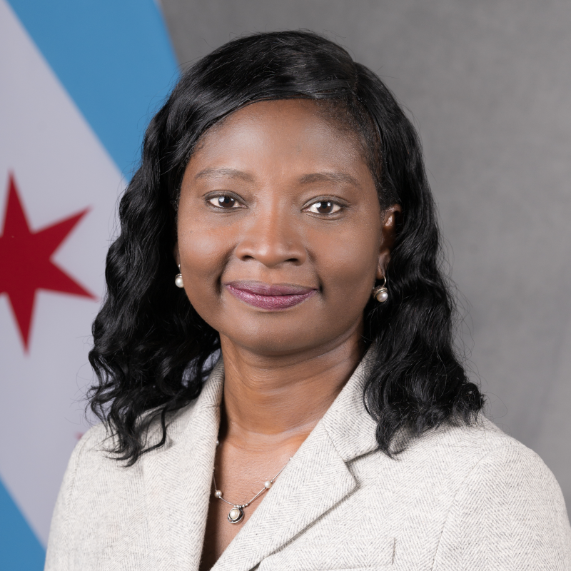 Headshot of Simbo Ige, in front of Chicago flag