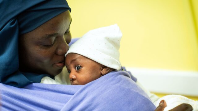Woman holding a swaddled newborn