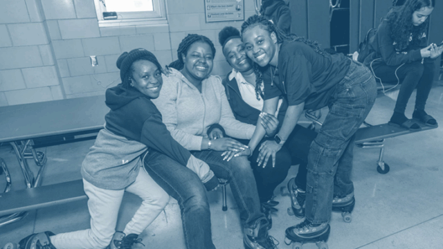 Group of teens sitting closely together on a bench