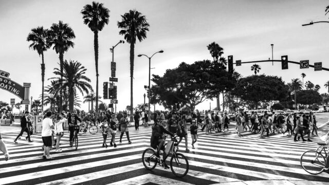 People biking and walking at a busy intersection near the beach in LA. Photo by Jack Finnigan on Unsplash.