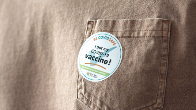 close up of shirt with "I got the COVID vaccine" sticker on it
