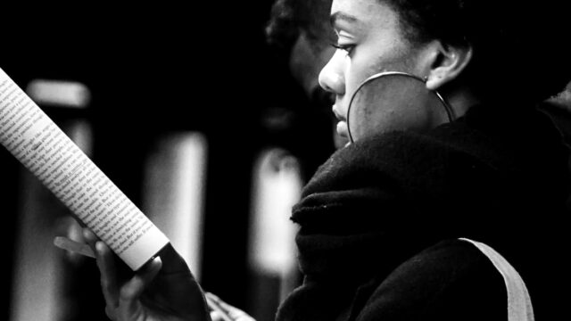 Woman reading magazine at subway station. Photo by Sash Margrie Hunt on Unsplash.